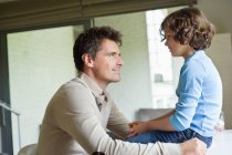Man with his son looking at each other at home — Stock Photo