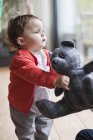 Mignon bébé fille tenant un ours en peluche — Photo de stock