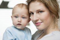 Close-up of thoughtful woman holding cute baby girl — Stock Photo