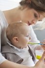 Close-up of woman feeding cute baby daughter — Stock Photo