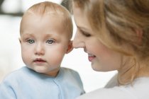 Close-up de mulher olhando para o bebê bonito menina com olhos azuis — Fotografia de Stock