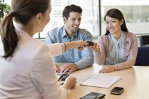 Couple receiving keys from business executive in office — Stock Photo