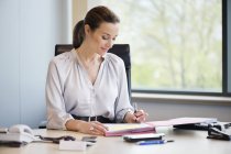 Smiling elegant businesswoman working in office — Stock Photo