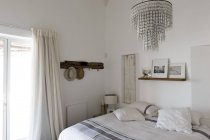 Interior of modern stylish bedroom with elegant chandelier — Stock Photo