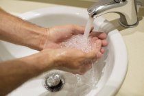 Крупним планом людина миє руки під краном — стокове фото