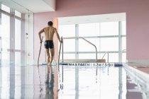 Homem atlético alto saindo da piscina — Fotografia de Stock