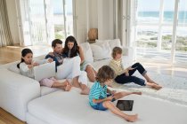 Famille utilisant gadget électronique — Photo de stock