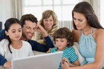Famille regardant un ordinateur portable — Photo de stock