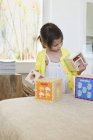 Menina bonito brincando com cubos aninhados em casa — Fotografia de Stock
