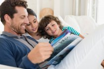 Mann liest mit seinen Kindern eine Zeitschrift — Stockfoto