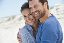 Portrait of happy romantic couple embracing on beach — Stock Photo