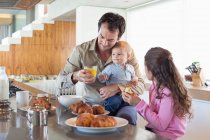 Сім'я снідає за кухонною стійкою — стокове фото