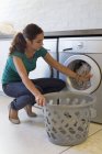 Woman doing laundry with washing machine at home — Stock Photo