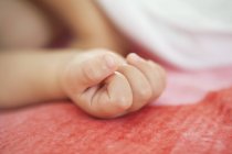 Gros plan de la main du bébé dormant au lit sur fond flou — Photo de stock
