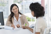 Businesswomen working in office, woman signing document in office — Stock Photo
