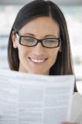 Primer plano de la mujer leyendo el documento y sonriendo - foto de stock