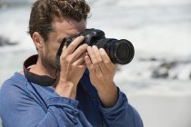 Close-up de homem com câmera fotografando na praia — Fotografia de Stock