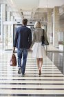 Elegant couple walking at airport holding hands — Stock Photo