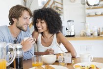 Couple sitting at dining table and having breakfast — Stock Photo