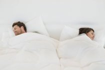Couple sleeping on bed with white linen — Stock Photo
