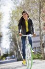 Sorridente giovane donna in bicicletta all'aperto — Foto stock