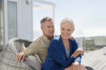 Romantic senior couple sitting in wicker chair outdoors — Stock Photo