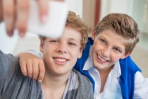 Двоє хлопчиків-підлітків фотографують себе з мобільним телефоном — стокове фото