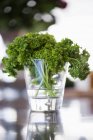 Parsley in glass on table, selective focus — Stock Photo