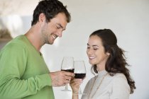 Casal brinde com copos de vinho e sorrindo — Fotografia de Stock