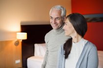 Coppia sorridente in piedi insieme in camera d'albergo — Foto stock