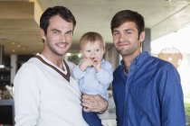 Портрет щасливих батьків lgbt посміхаються з сином вдома — стокове фото