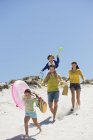 Щаслива родина, що гуляє на піщаному пляжі влітку — стокове фото