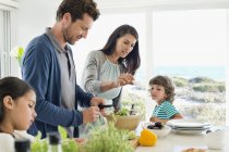 Famiglia felice preparare il cibo in casa costiera — Foto stock