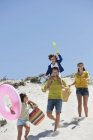 Felice passeggiata in famiglia sulla spiaggia di sabbia in estate — Foto stock