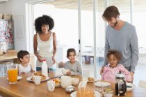 Familie lächelt am Frühstückstisch — Stockfoto