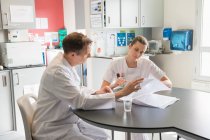 Doctor and nurse analyzing medical record in a hospital — Stock Photo
