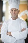 Portrait of confident male chef with arms crossed in restaurant — Stock Photo