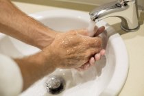 Close-up de homem lavar as mãos sob torneira — Fotografia de Stock