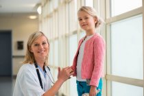 Portrait of a female nurse smiling with a girl — Stock Photo