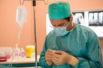 Chirurg untersucht medizinische Geräte im Operationssaal — Stockfoto