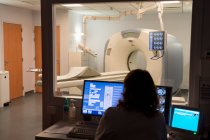 Medical practitioner examining MRI scan in monitor room — Stock Photo