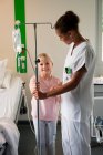 Female nurse assisting to a girl patient in hospital — Stock Photo