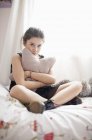 Seria ragazza adolescente seduta sul letto — Foto stock