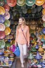Donna che fa shopping nel negozio di ceramiche di souk, Marrakech, Marocco — Foto stock