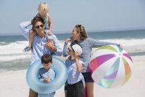 Familia joven disfrutando de vacaciones en la playa - foto de stock