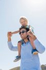 Junger Mann trägt seinen Sohn auf den Schultern — Stockfoto