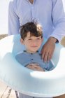 Happy father and son with rubber ring on beach — Stock Photo
