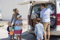 Junge Familie packt Auto mit Strandausrüstung für den Urlaub — Stockfoto