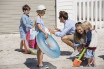 Felice giovane famiglia con attrezzi da spiaggia per le vacanze — Foto stock