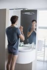 Reflexão do homem olhando para o espelho do banheiro — Fotografia de Stock